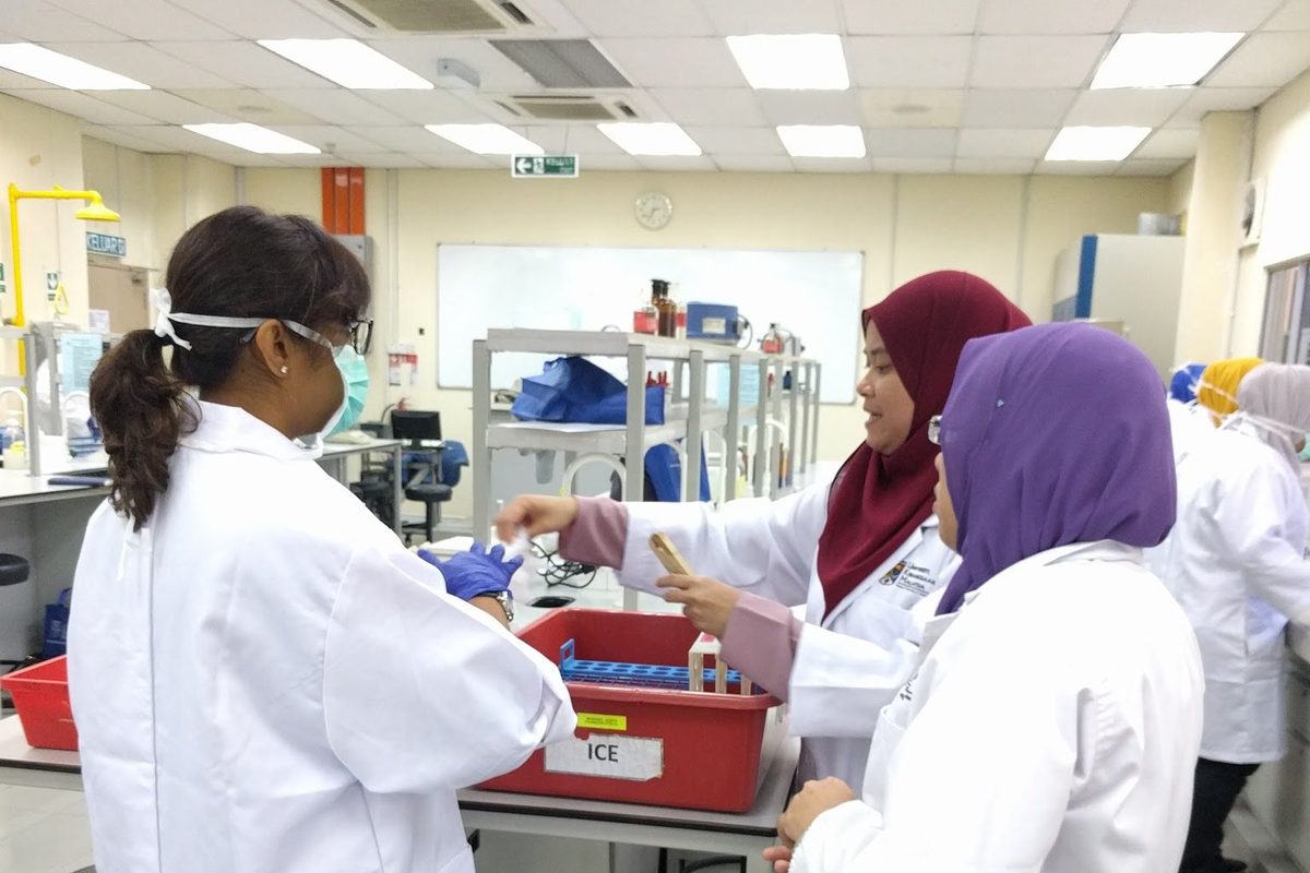 Participants in lab coats at work in the laboratory