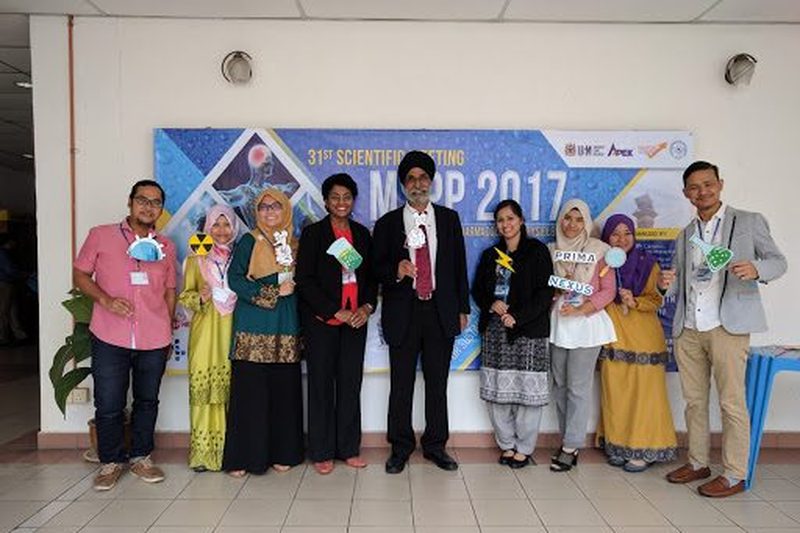 Nine delegates stand in a row with photo props in front of the MSPP 2017 banner