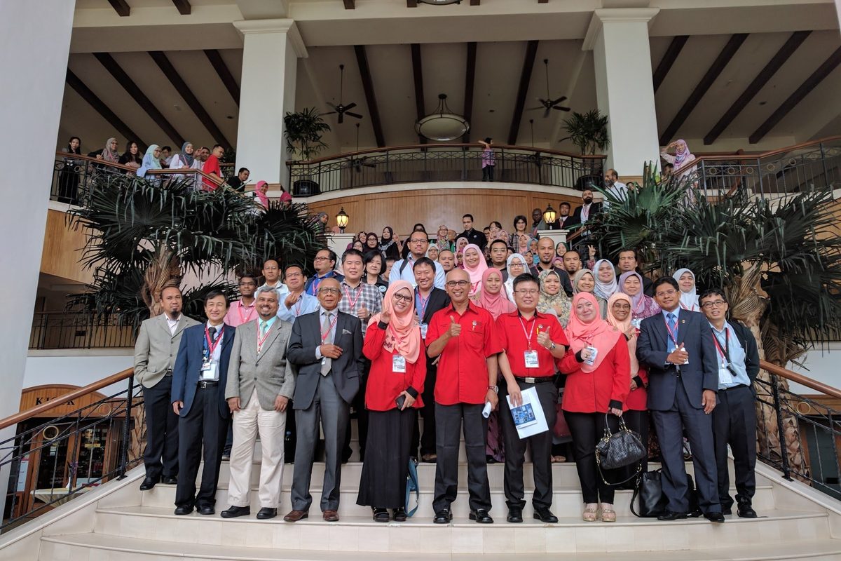 Speakers and participants in a group photo on a hotel staircase