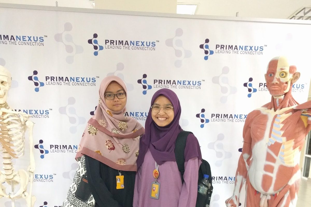 Two delegates beside a muscle anatomy model at the Prima Nexus photo wall