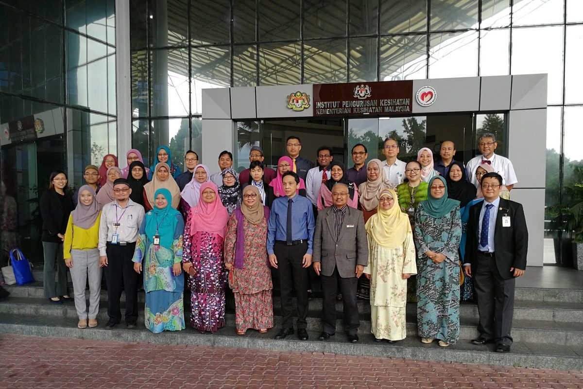 Workshop participants in a large group photo outside the Institute for Health Systems Research building