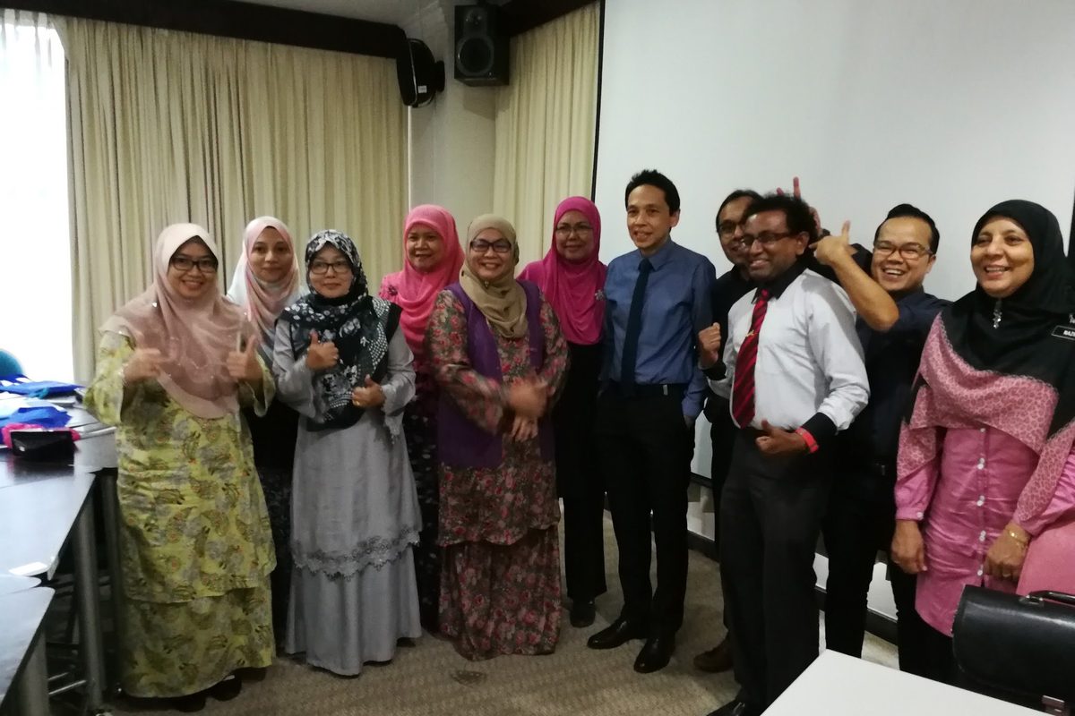 Participants stand together for a group photo in the workshop room
