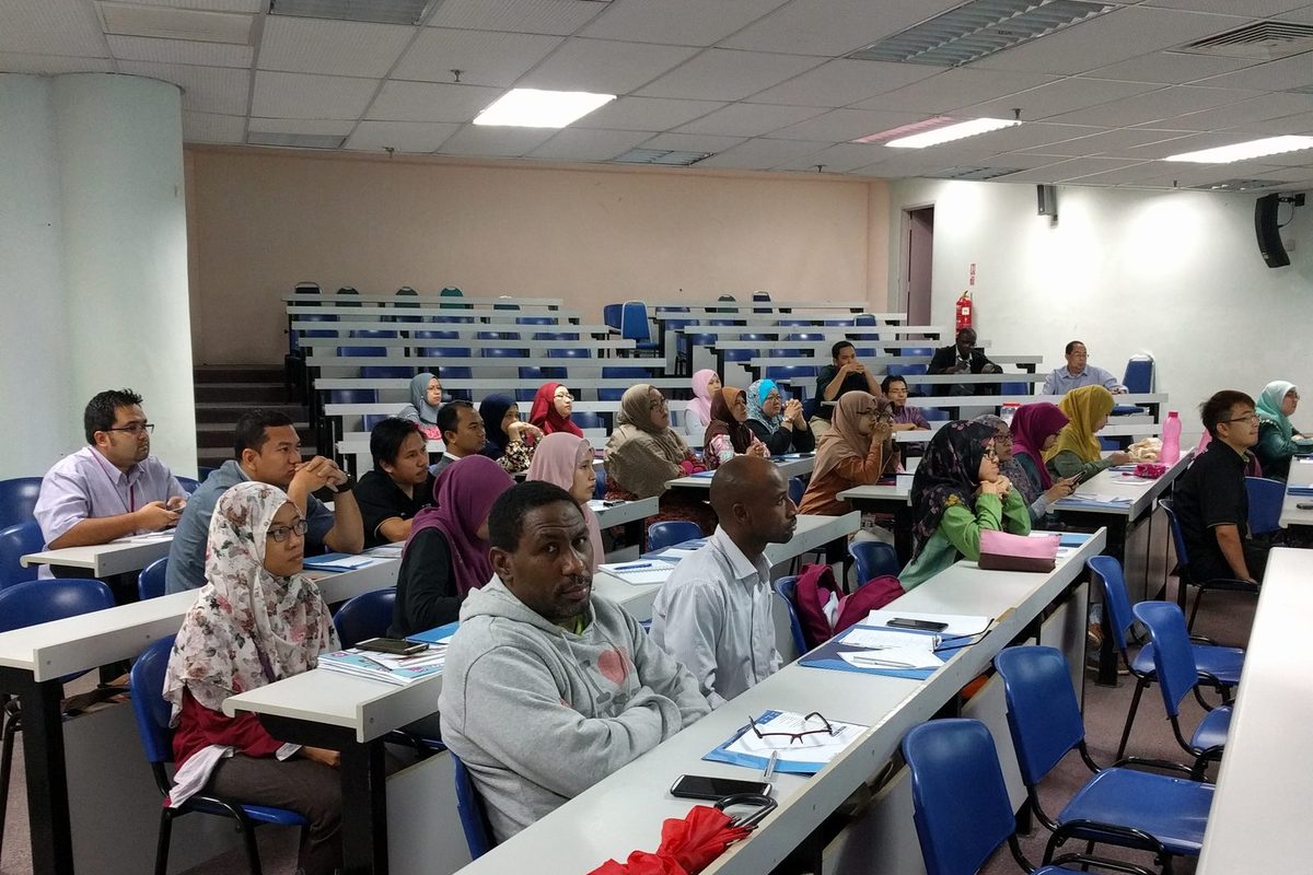Participants at their desks, listening to a session