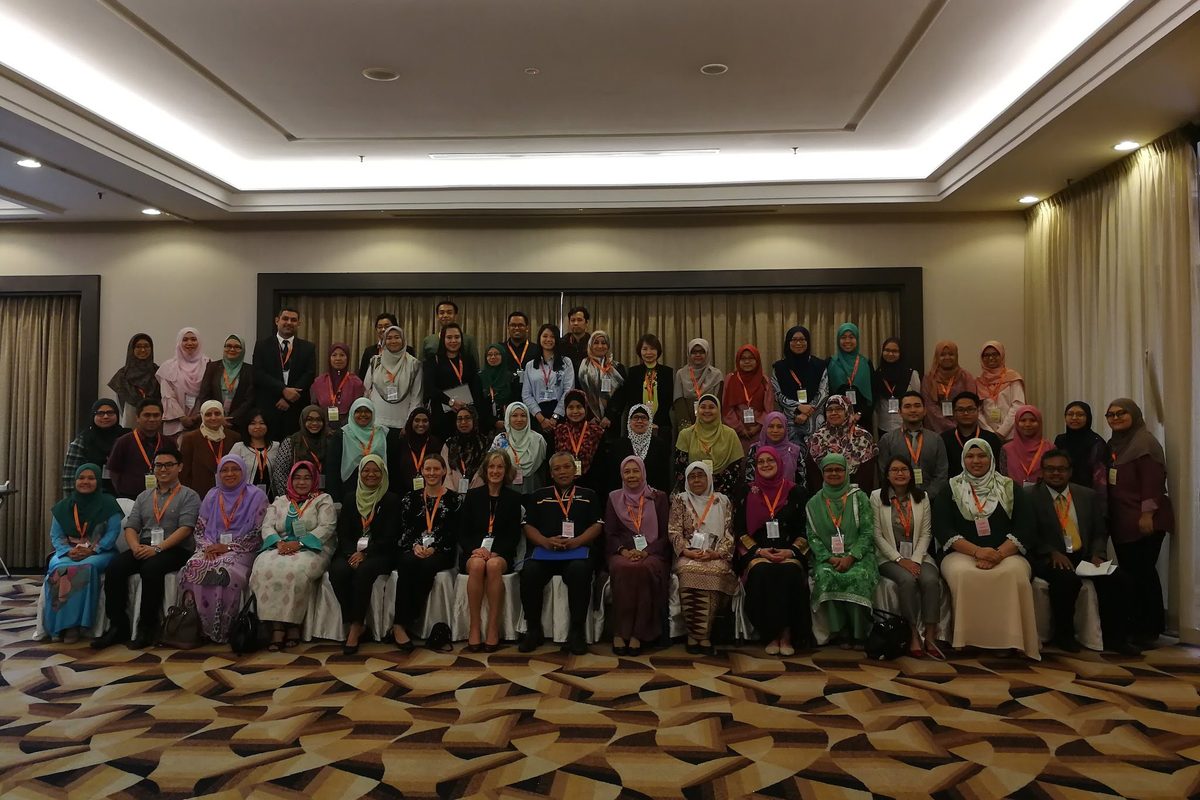 Large group photo of conference delegates in a hotel ballroom