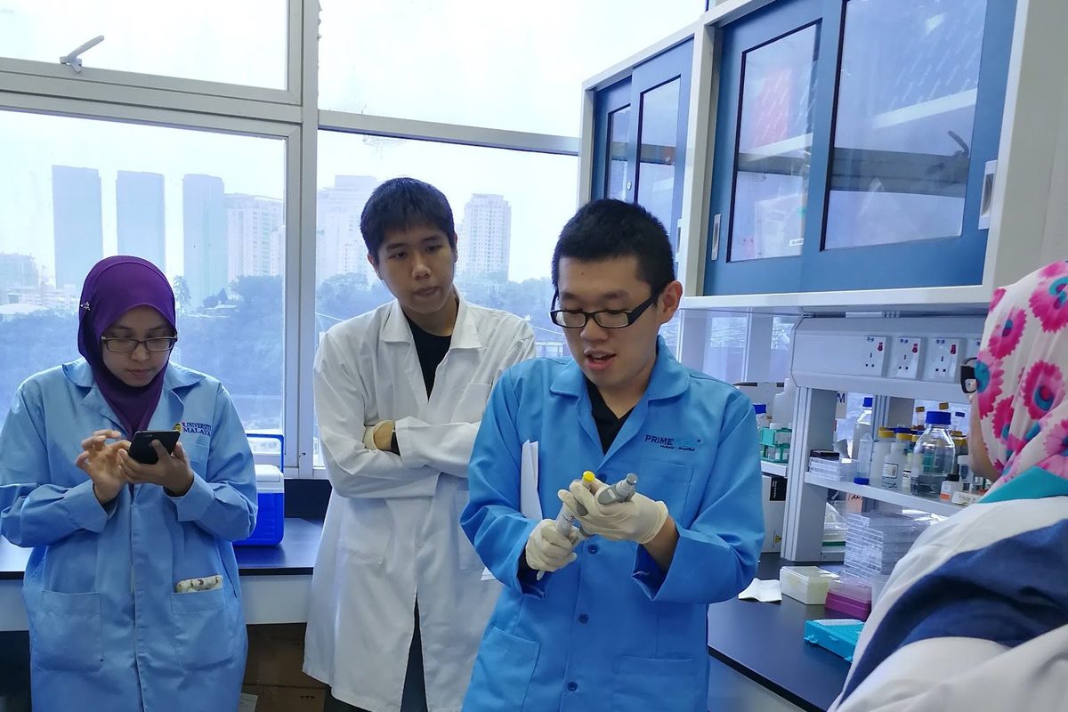 Participants in blue lab coats standing in the laboratory