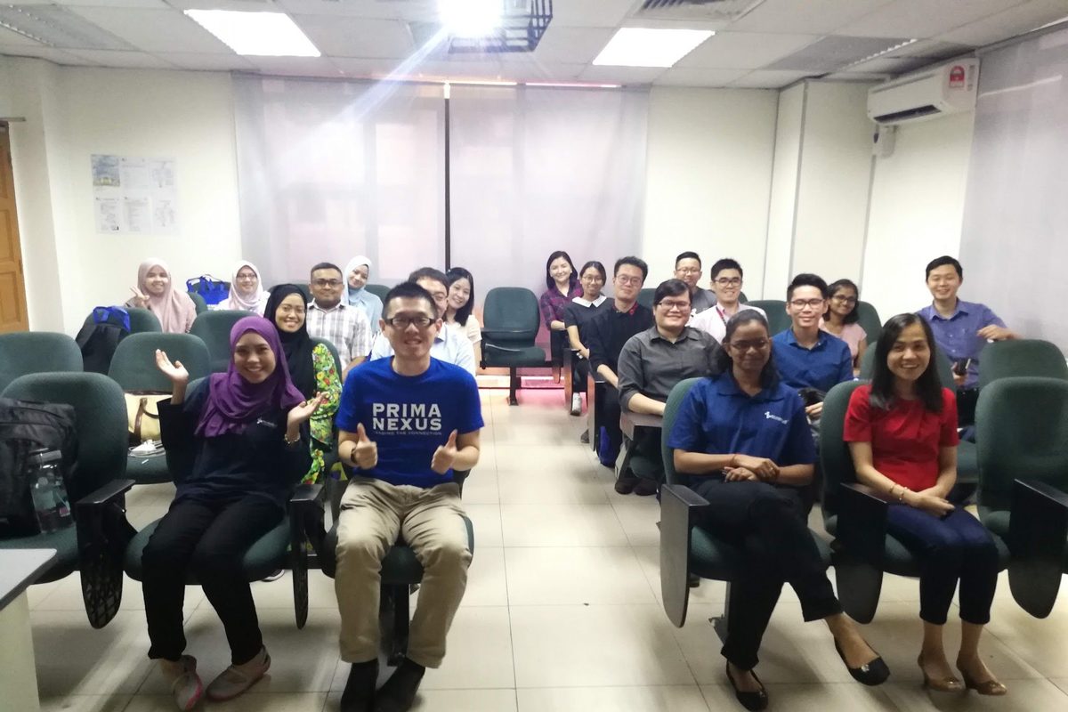 Workshop participants seated in rows in the lecture room for a group photo