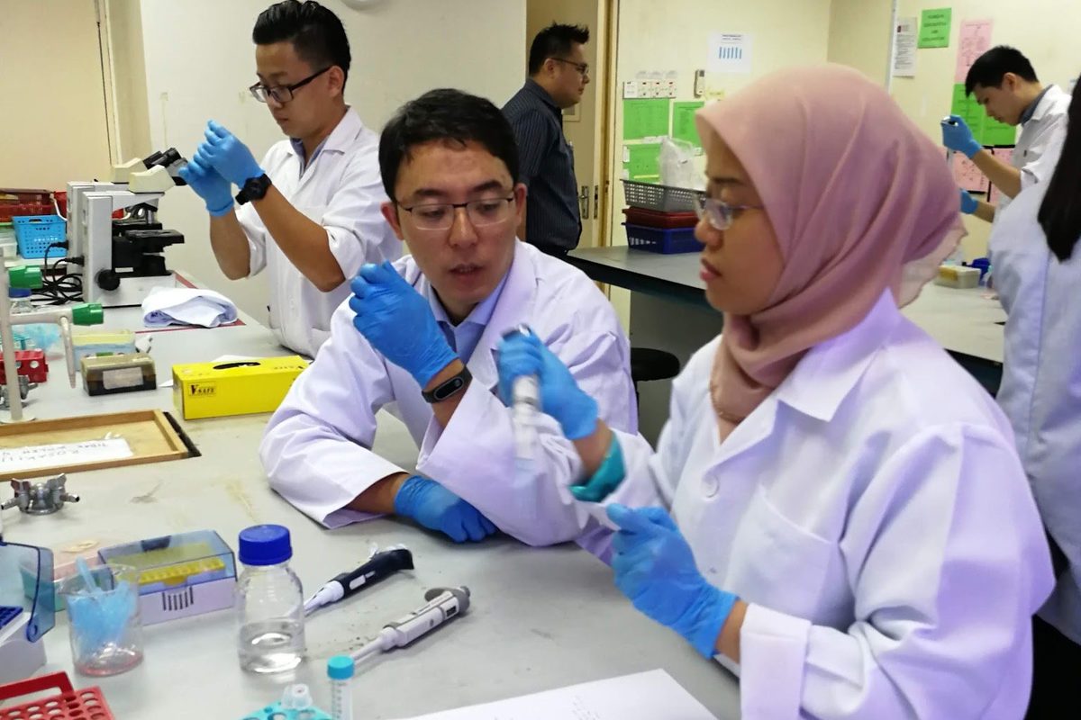 Participants in lab coats at the laboratory bench