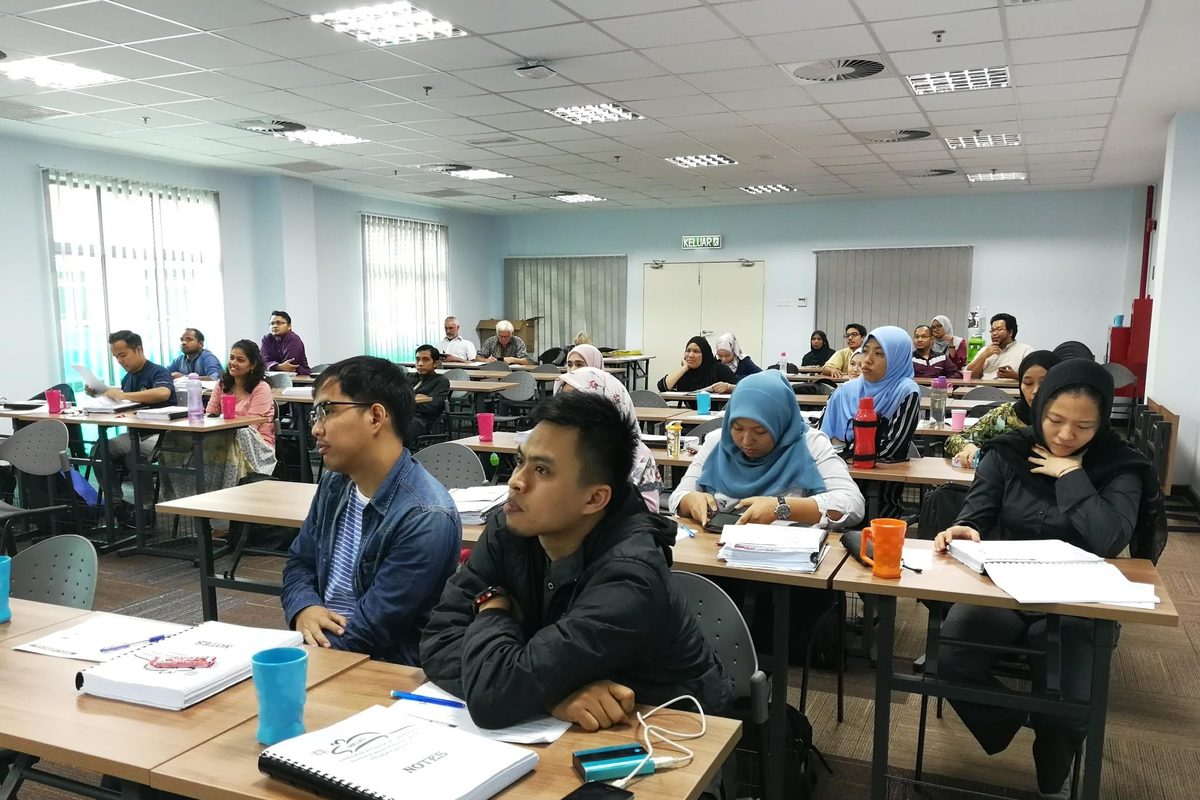 Participants seated at rows of computers during a session