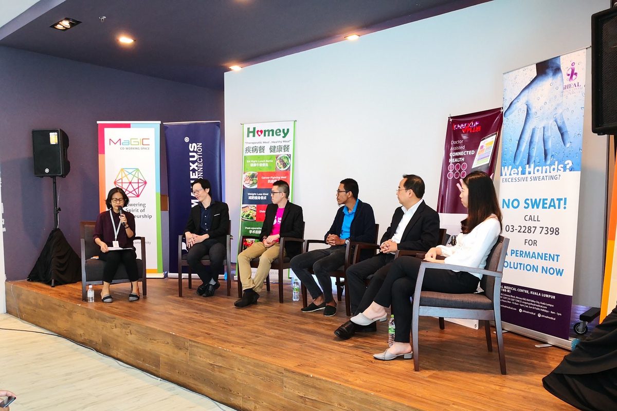 Panel speakers seated on the stage in front of the audience