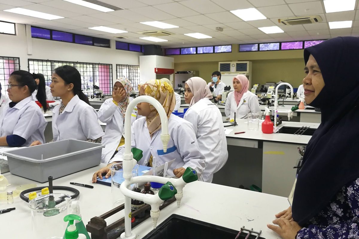 Participants in lab coats at the laboratory benches