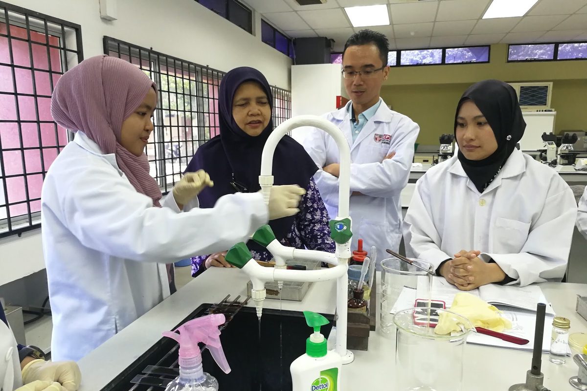 A trainer demonstrates a step to participants at the bench