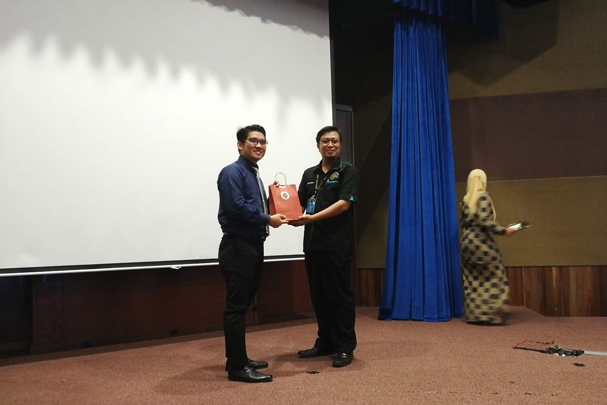 An IIUM host thanks the Prima Nexus speaker on the stage of the lecture hall