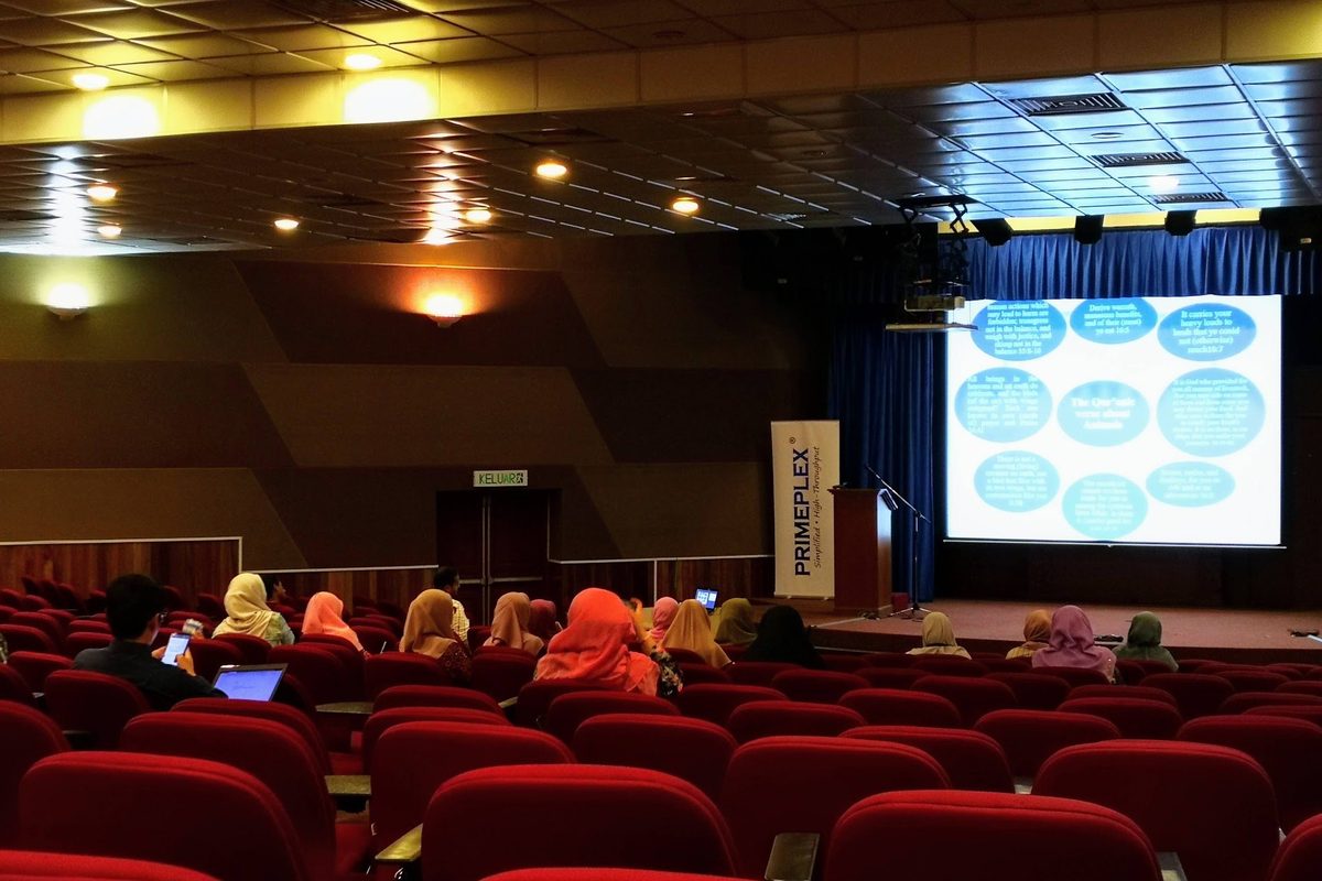 Participants seated in the lecture hall at IIUM Kuantan, watching a talk on the screen