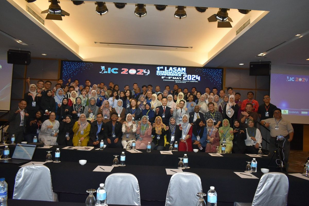 Full-room group photo of LIC 2024 participants in front of the LIC 2024 backdrop
