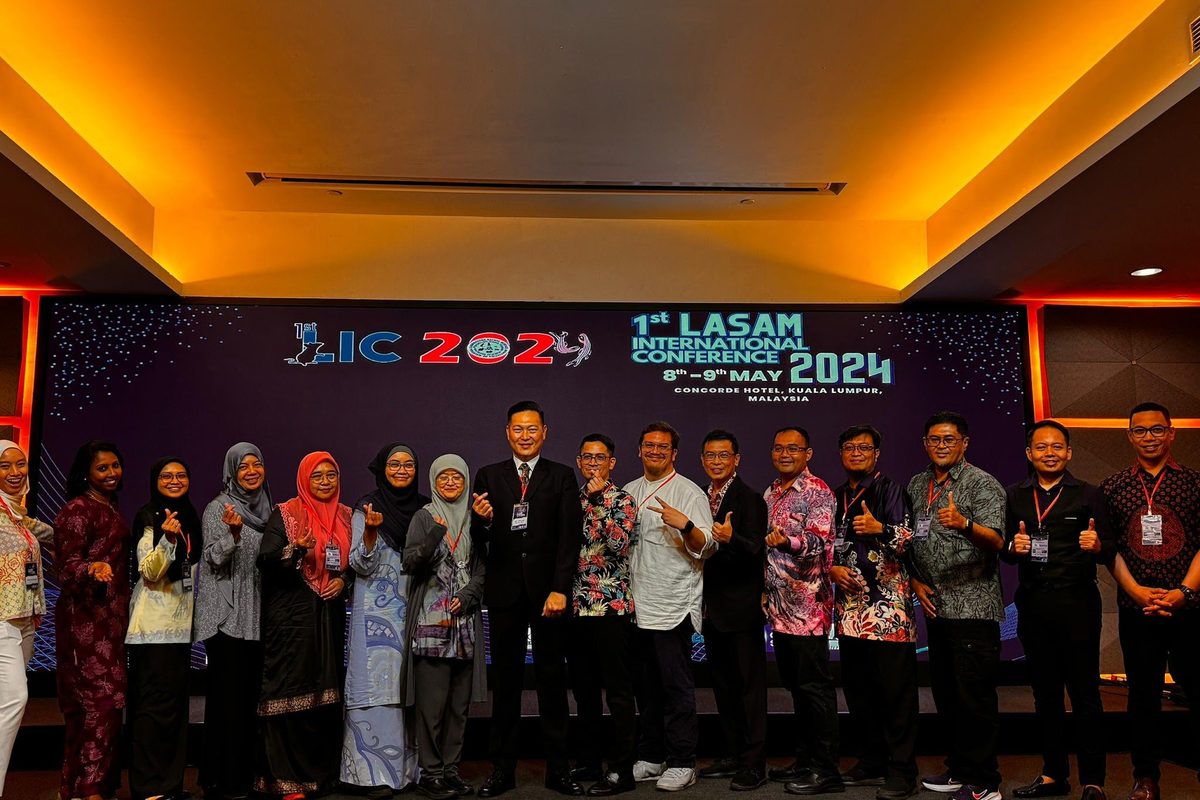 Organisers and speakers stand in a row on the stage in front of the LIC 2024 backdrop