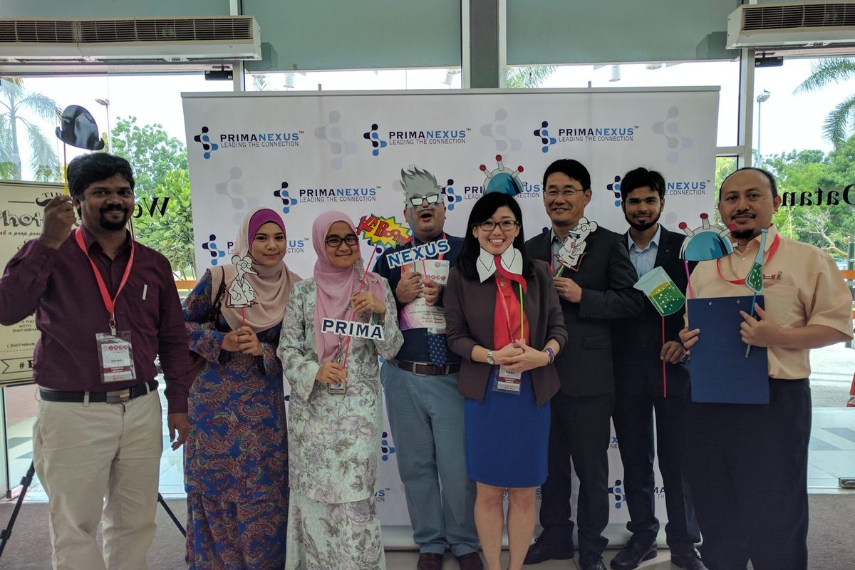 Delegates holding science-themed props in front of the Prima Nexus backdrop at IABS2017