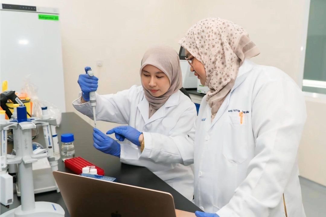 Two researchers in lab coats working at a laboratory bench