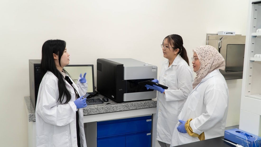 Scientists discussing results at a laboratory instrument