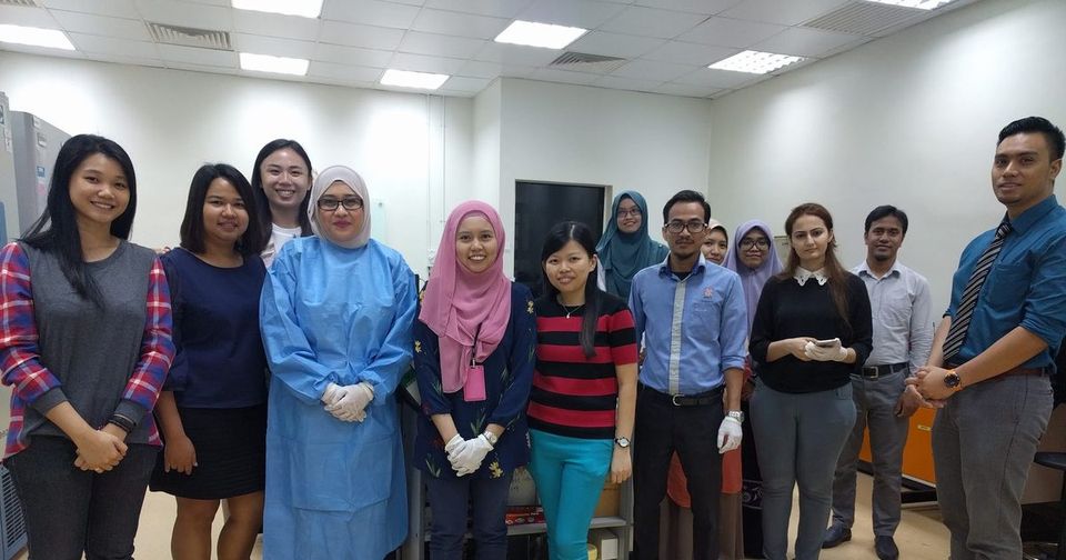 Workshop participants and trainers stand together for a group photo in a laboratory