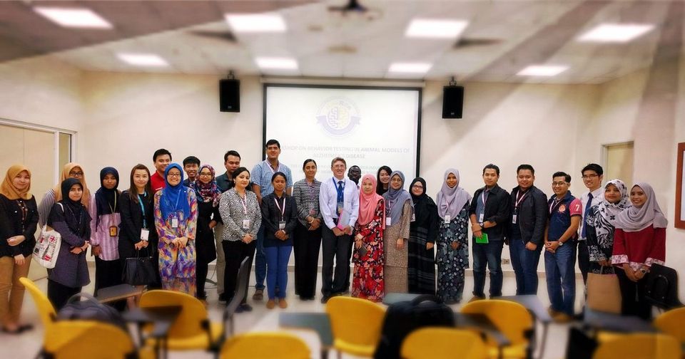 A large group of participants and organisers standing together for a group photo in a seminar room