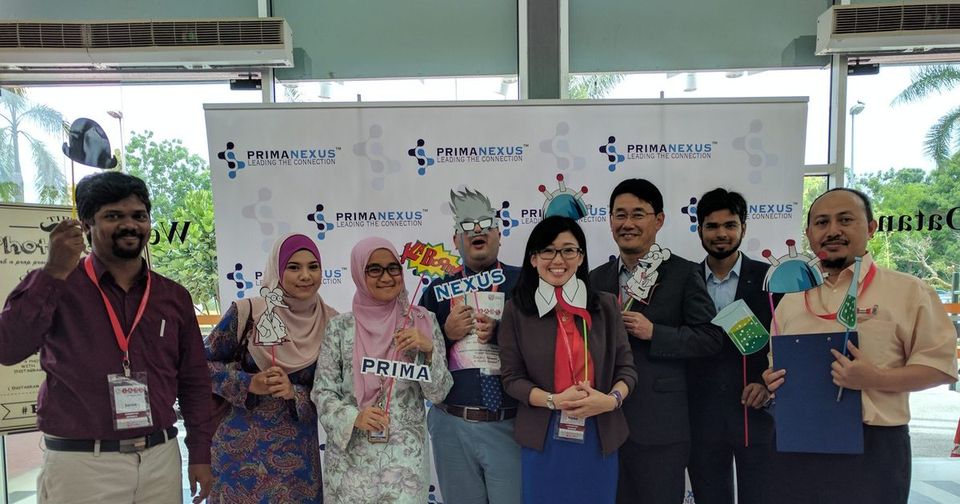 Delegates holding science-themed props in front of the Prima Nexus backdrop at IABS2017