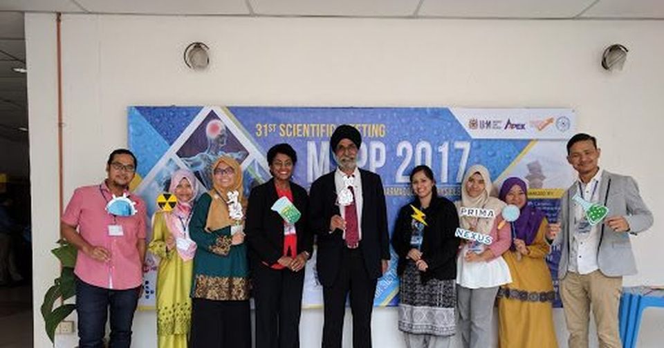 Nine delegates stand in a row with photo props in front of the MSPP 2017 banner