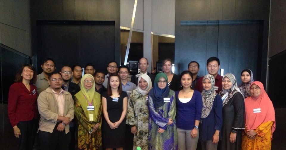 Group photo of participants standing together in a hotel meeting room