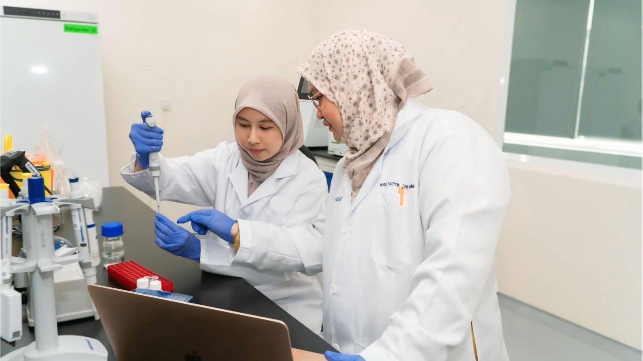 Two researchers in lab coats working at a laboratory bench