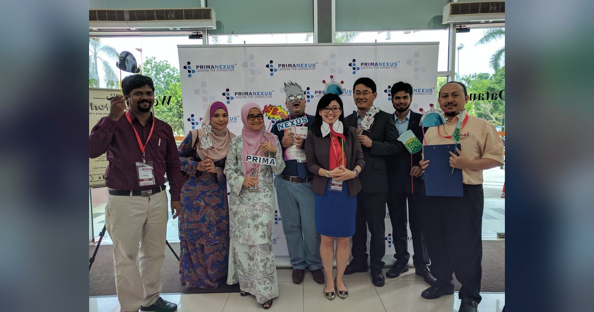 Delegates holding science-themed props in front of the Prima Nexus backdrop at IABS2017