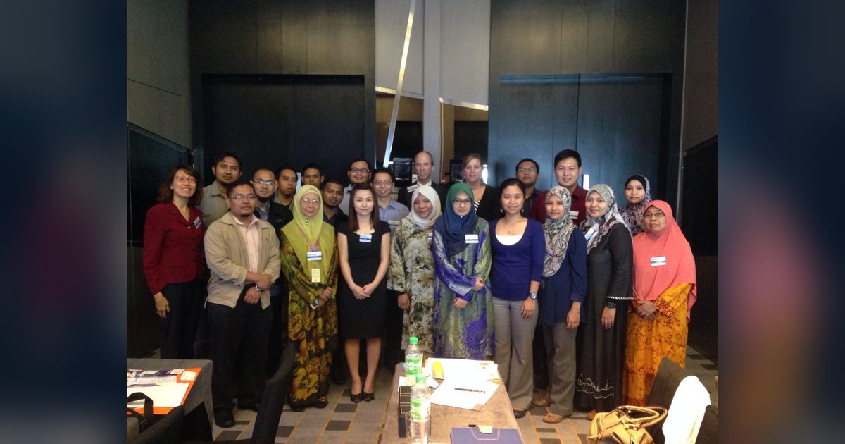Group photo of participants standing together in a hotel meeting room
